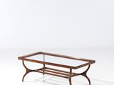 une table basse avec un plateau en verre, un piètement en bois et des pieds en métal