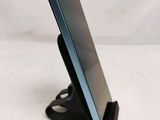 a close up of a cell phone on a stand on a white surface