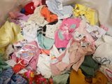 a large pile of baby clothes in a plastic bag