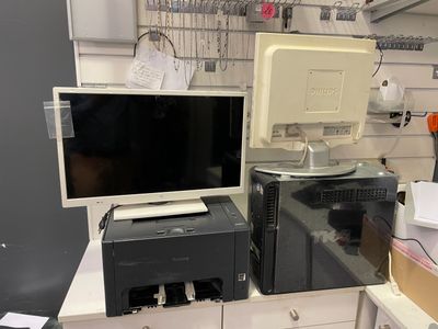 un ordinateur et une imprimante posés sur un bureau dans une pièce