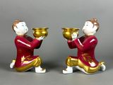 pair of ceramic figurines of a man and a woman holding bowls