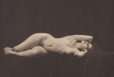 une vieille photo en noir et blanc d'une femme nue allongée sur le dos