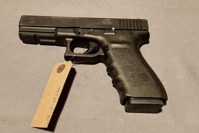 a gun with a tag attached to it sitting on a table