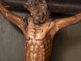 a statue of jesus on the cross with a bell in the background