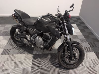 une moto noire garée sur un sol à damier