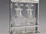 three glass bottles in a metal holder on a table