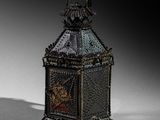 a small metal lantern sitting on a white surface