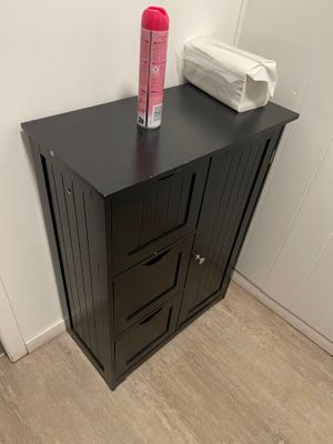 une armoire noire surmontée de deux tiroirs