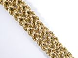 a close up of a gold chain bracelet on a white surface