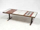 une photo d'une table basse avec un plateau en carrelage et des pieds en métal