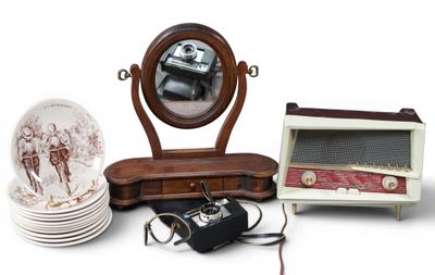 a table with a mirror, a plate, a camera, and other items
