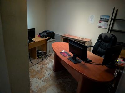 a desk with a computer and a chair in the corner