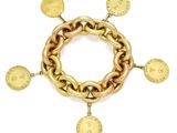 Gros plan sur un bracelet en or orné de pièces de monnaie