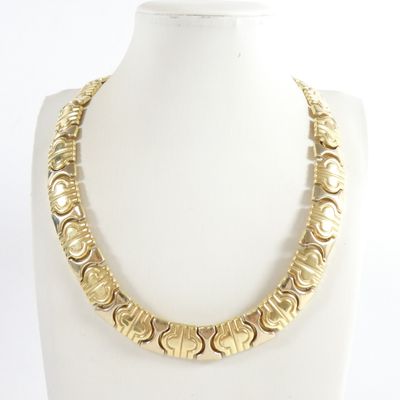 a close up of a gold necklace on a mannequin mannequin
