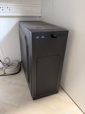 a black computer sitting on the floor next to a wall