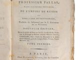 un vieux livre ouvert, dont une page de texte apparaît sur fond blanc