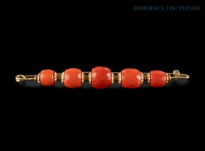 un gros plan d'un bracelet en perles rouges sur fond noir