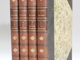 une pile de quatre livres posés les uns sur les autres sur une surface blanche