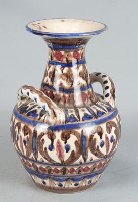 a vase with a bird on it sitting on a table
