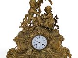a gold clock with figures on it on a white background