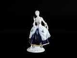 figurine représentant une femme en robe bleue tenant un panier de fleurs