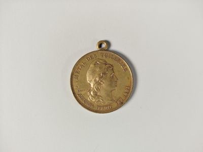 a close up of a gold coin on a white surface