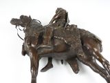 bronze statue of a man riding a horse with a rider on the back