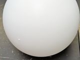 a white ball sitting on top of a table next to a banana