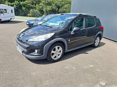 la photo d'une petite voiture noire garée dans un parking