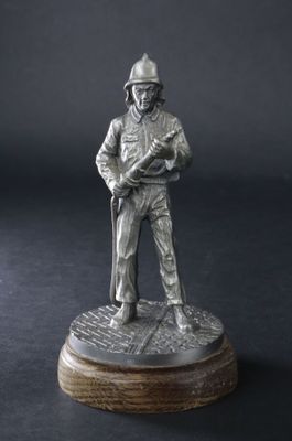 "Pompier tenant une lance", sujet en alliage sur base de boi…