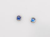 a pair of blue glass stud earrings on a white surface