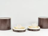 three brown and white tins sitting next to each other on a white surface
