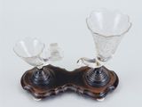 two glass vases sitting on a wooden stand