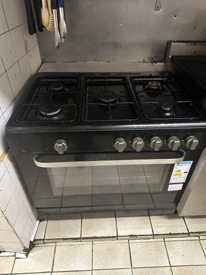 un poêle noir dans une cuisine au sol carrelé