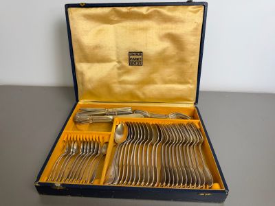 silverware in a blue case on a table with a gold lining