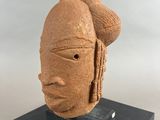 a sculpture of a woman ' s head on a black stand