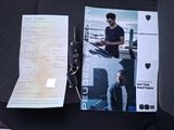 a picture of a man sitting in a car seat with a ticket and a car key