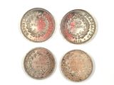 four different types of silver coins on a white surface