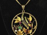 un collier en or orné d'un oiseau et de fleurs