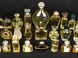 de nombreux flacons de parfum de toutes sortes posés sur une surface noire