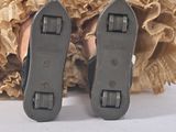 two pairs of shoes sitting on top of a piece of wood