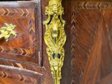 a gold handle on a wooden dresser in a room