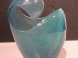 a blue glass vase sitting on a white table