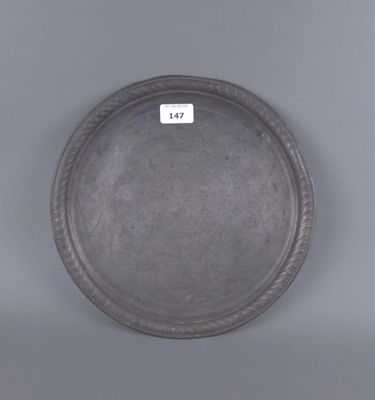 une image représentant une assiette en argent posée sur une surface grise
