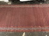 On voit une image représentant un tapis rouge posé sur le sol d'une pièce.