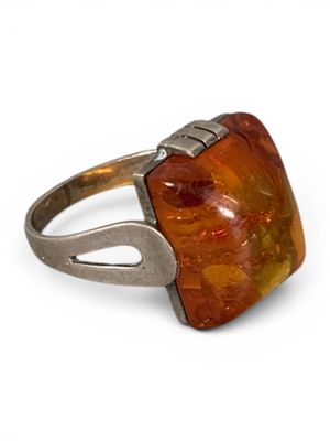 un gros plan d'une bague sertie d'une pierre orange