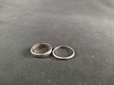 pair of silver wedding rings on a black surface