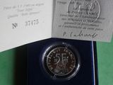 a silver coin in a blue box on a green surface