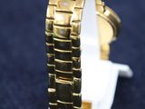 a close up of a gold watch on a blue surface