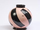 a black and pink vase sitting on a white surface